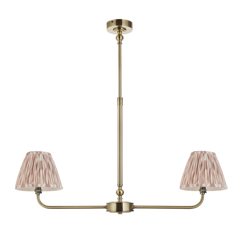 A refined ceiling light featuring an brass frame with two curved arms, each supporting a classic tapered fabric clip shade. 