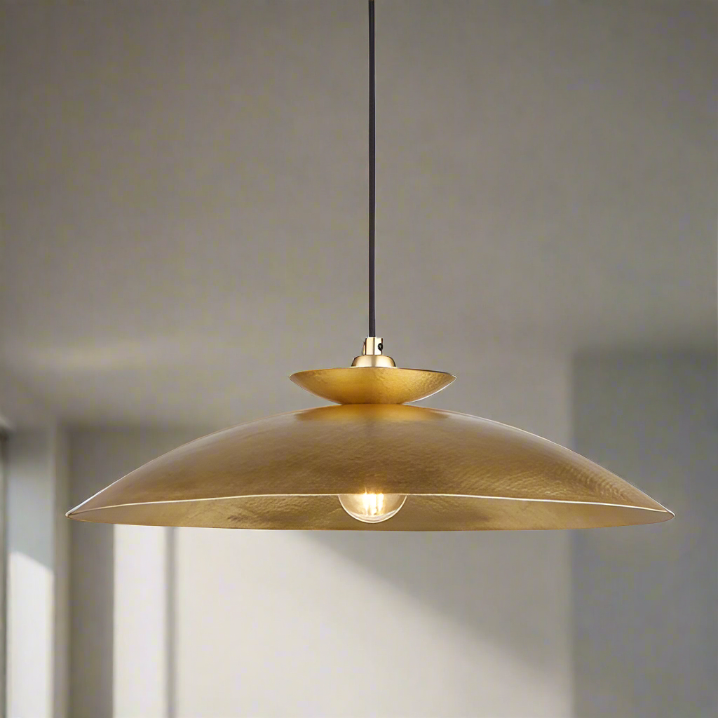 Modern pendant featuring a hammering brass metalwork finish with a black flex. This brass disc pendant light is a striking, contemporary lighting fixture that combines sleek design with industrial charm. 