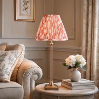 Brass table lamp with red Ikat shade on wooden side table in elegant living room