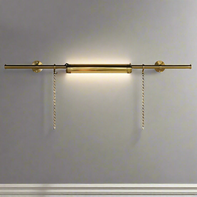 Elevate your artwork or wall décor with this elegant brass picture light, designed for both function and timeless style. Featuring a sleek cylindrical light bar in a warm brass finish, it casts an even, flattering glow across your painting or photograph. The fixture is mounted on a central pole, from which two decorative brass chains extend to secure it to the frame or wall, ensuring both stability and a sophisticated look.

Perfect for galleries, living rooms, or hallways, this brass picture light highligh
