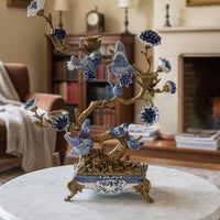 Blue porcelain bird tree candelabra with gold accents on marble table in living room