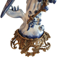 Decorative ceramic piece with blue and white design on a gold ornate base.