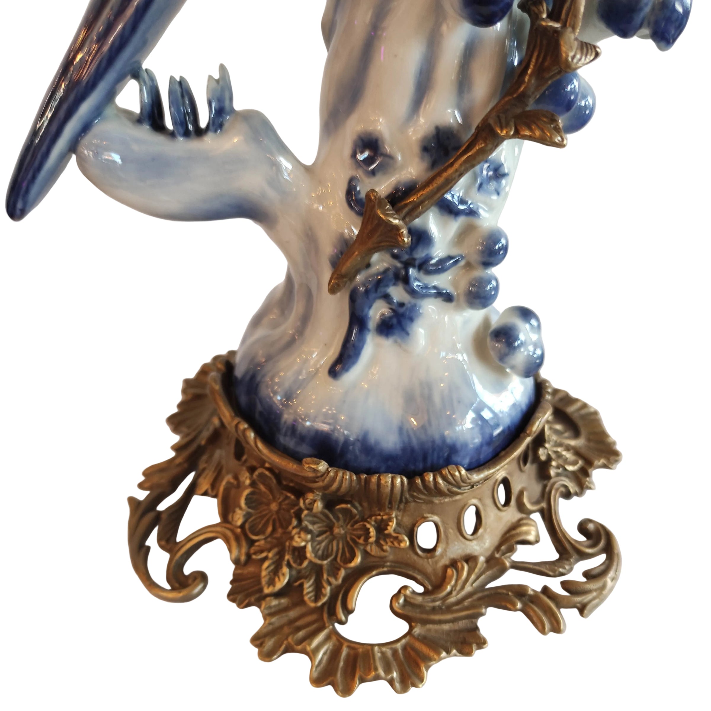 Decorative ceramic piece with blue and white design on a gold ornate base.