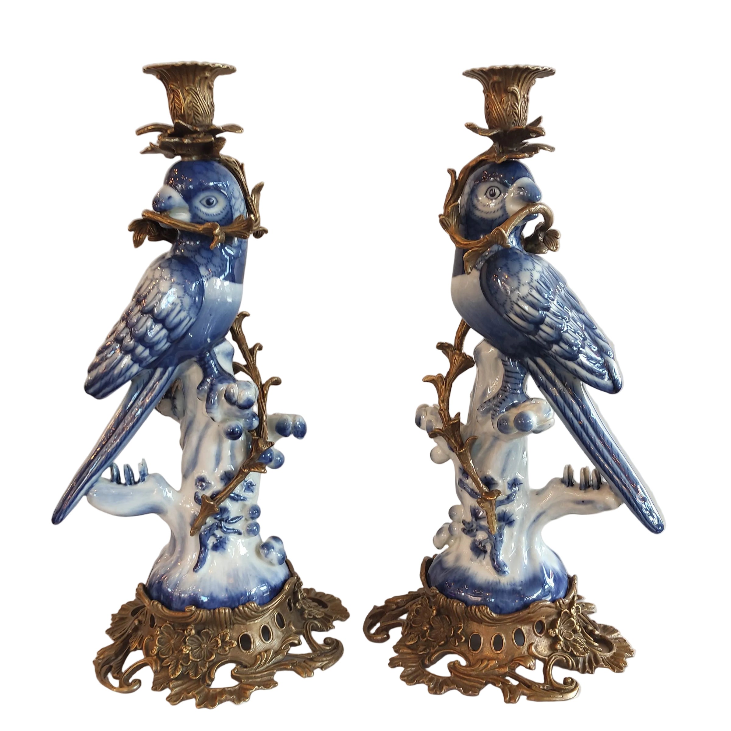 Decorative candle holders with blue floral designs on a white surface
