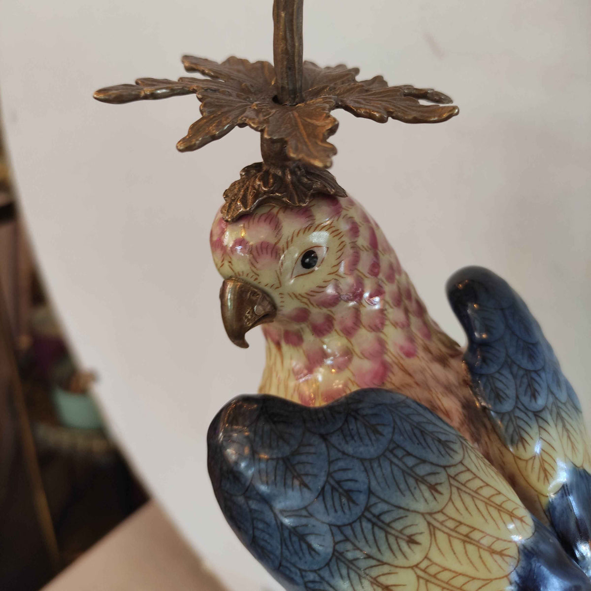 A pair of a colourful porcelain parrot candle holders with gilt bronze detailing. Crafted to exceptional quality, they add luxurious warmth and timeless charm to refined interiors