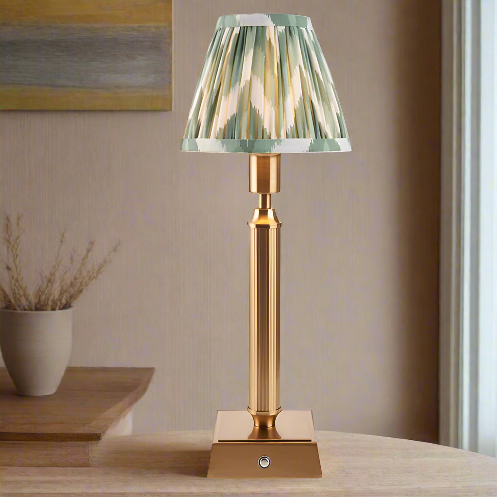 Brushed gold, rechargeable table lamp with a USB port.&nbsp; This portable, rechargeable 3 stage touch dimmer table lamp allows you to set your desired level of light.
They include a USB cable and an integrated warm white LED bulb.
These lamps are so convenient, can be placed wherever needed, no wires or plugs. Perfect for dining tables, desks or bedrooms. Can even be used outdoors making this a totally versatile lighting solution for your home.
Combine them with a beautiful pleated clip shade in three diff