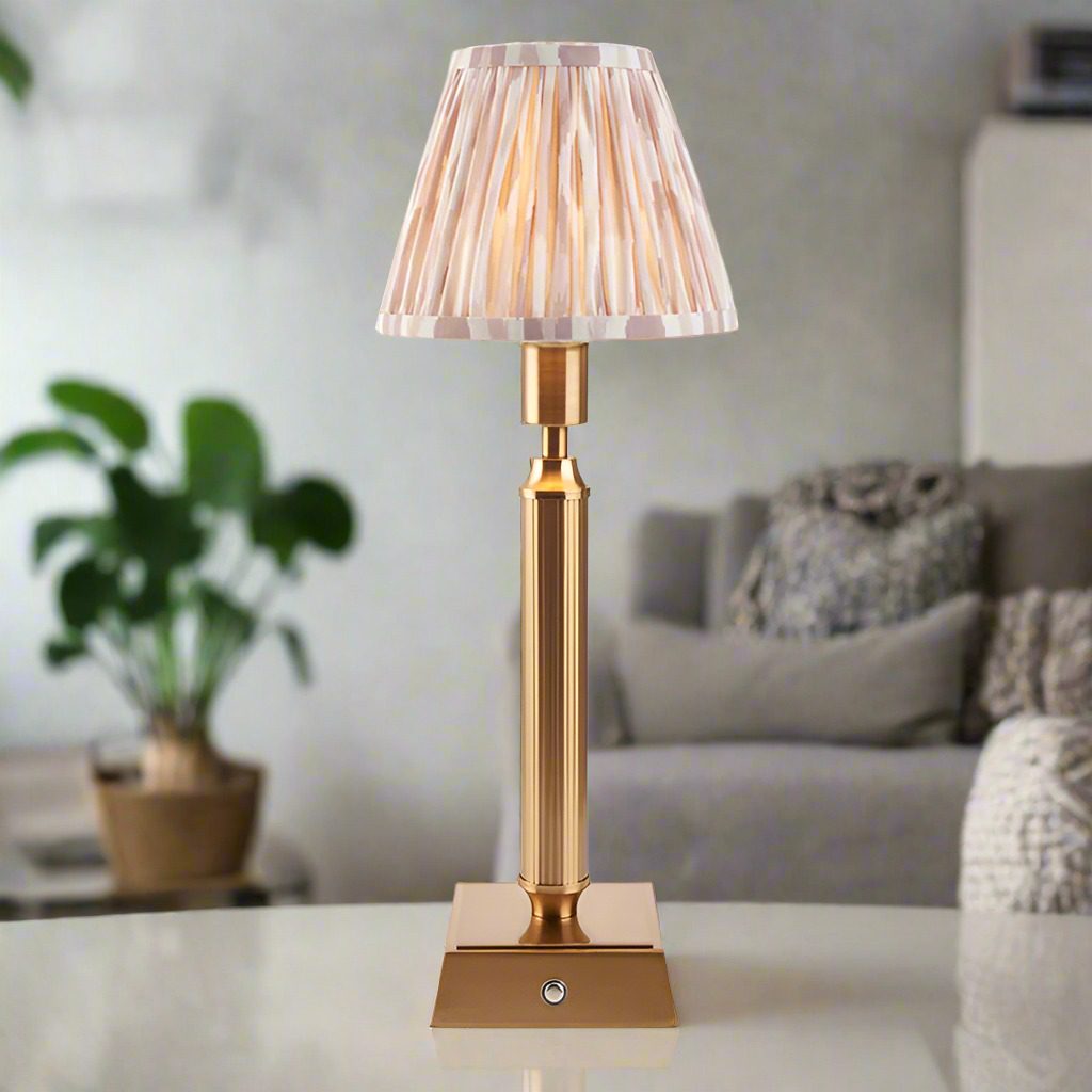Brushed gold, rechargeable table lamp with a USB port.&nbsp; This portable, rechargeable 3 stage touch dimmer table lamp allows you to set your desired level of light.
They include a USB cable and an integrated warm white LED bulb.
These lamps are so convenient, can be placed wherever needed, no wires or plugs. Perfect for dining tables, desks or bedrooms. Can even be used outdoors making this a totally versatile lighting solution for your home.
Combine them with a beautiful pleated clip shade in four diffe