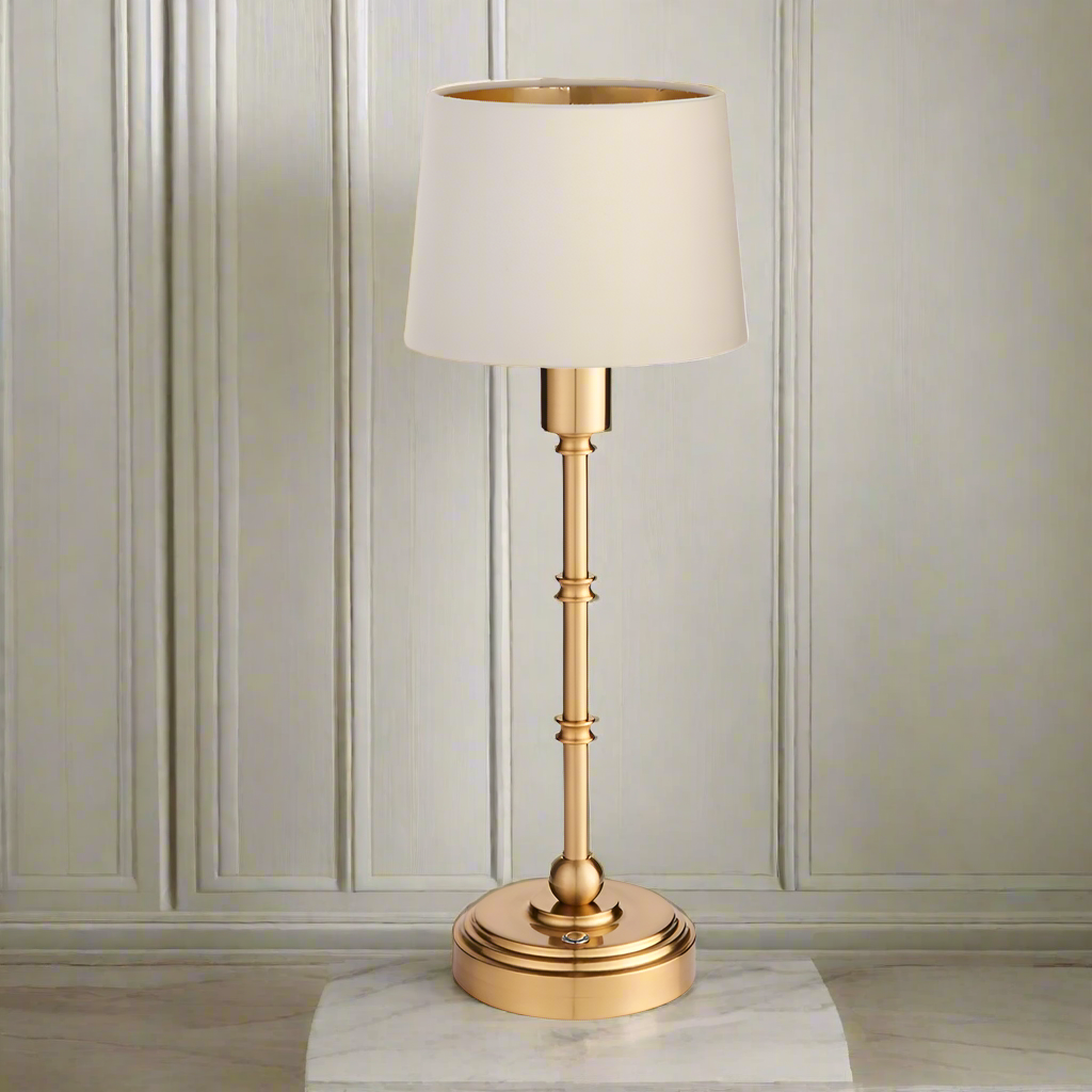 Brushed gold, rechargeable table lamp with a USB port.&nbsp; This portable, rechargeable 3 stage touch dimmer table lamp allows you to set your desired level of light.
They include a USB cable and an integrated warm white LED bulb.
These lamps are so convenient, can be placed wherever needed, no wires or plugs. Perfect for dining tables, desks or bedrooms. Can even be used outdoors making this a totally versatile lighting solution for your home.
Combine them with a inner gold clip shade in three different c