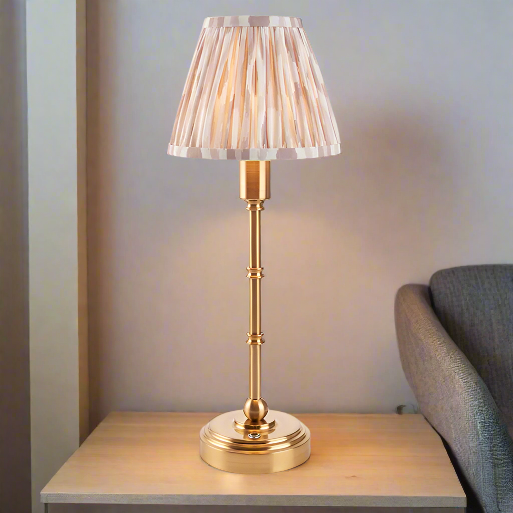 Brushed gold, rechargeable table lamp with a USB port.&nbsp; This portable, rechargeable 3 stage touch dimmer table lamp allows you to set your desired level of light.
They include a USB cable and an integrated warm white LED bulb.
These lamps are so convenient, can be placed wherever needed, no wires or plugs. Perfect for dining tables, desks or bedrooms. Can even be used outdoors making this a totally versatile lighting solution for your home.
Combine them with a beautiful pleated clip shade in four diffe