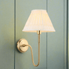 Curved brass wall light with a pleated fabric shade. Classic, slim wall light, a simple, elegant way to add light to you rooms.
