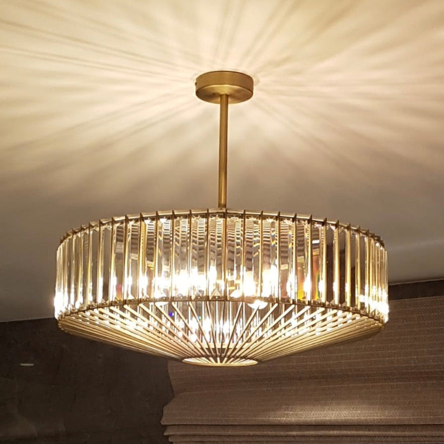 An elegant crystal and bronze chandelier with adjustable height. Its warm glow and geometric design elevate dining rooms, living rooms or hallways