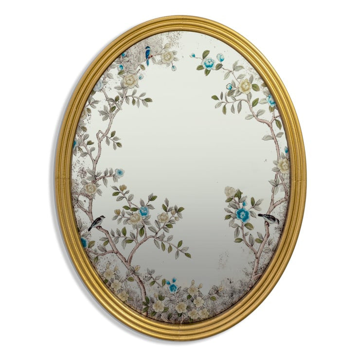 A decorative gilt framed oval wall mirror painted in the 'Victorian' style with floral motifs. A light-enhancing reflective glass surface. 