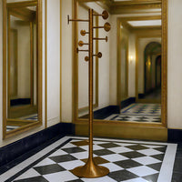 Modern aged brass coat rack with geometric design in a contemporary hallway setting