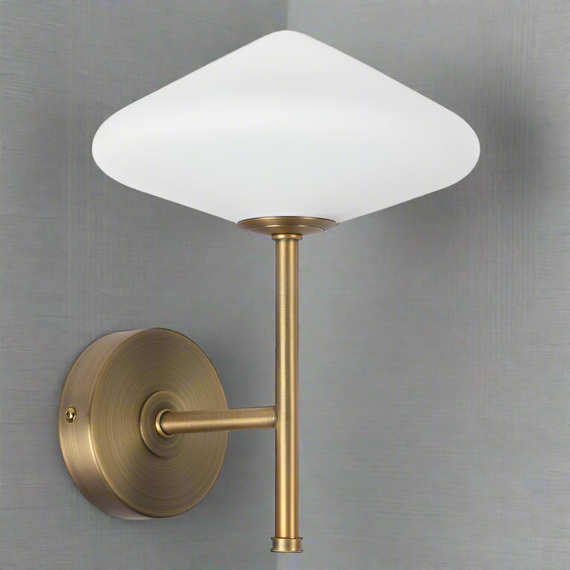 This very attractive wall light matches our White Glass and Gilt Metal Pendant.&nbsp; It would work beautifully independent of the ceiling light.&nbsp; It has the diamond shaped opaque glass globe on top of&nbsp; a brushed gilt metal stand.&nbsp; &nbsp;Standing 25 cm high and 20 cm in width, this is a compact, perfectly formed wall light which will unobtrusively brighten any wall.&nbsp; A stunning contemporary design, it will work in the most modern of interiors.

This light is IP20 rated and&nbsp; requires