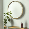 A round wall mirror with a distressed gold metal frame. The textured frame gives a vintage and rustic feel. The mirror itself is smooth and clear, providing a clean reflection. The combination of the aged gold finish and the simple, round shape creates a timeless, elegant look, making it suitable for various interior designs, from contemporary to more traditional spaces. This mirror suits any room and will add light, from every direction to any room.
