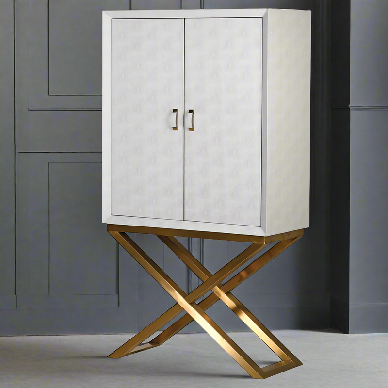 Fitted faux shagreen, ivory coloured cocktail cabinet on crossed gilt legs. Fitted ot inside with two lower drawers and hooks for glasses above. - luxurious piece of furniture.