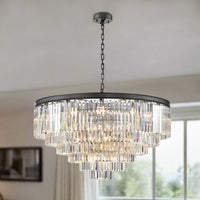 Large six-tier chandelier with a black metal band and cascading prism-cut crystal layers, suspended from an adjustable chain, in a living room