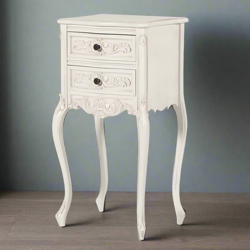 A whitewashed two-drawer bedside table in the 'Louis' style with curved legs and decorative serpentine front.