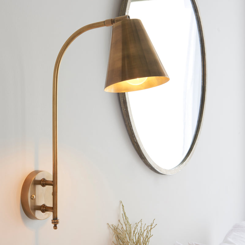 An elegant tall gilt metal wall light with gilt shade.