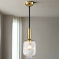 Clear, ribbed glass pendant with tall gilt metal fitting, a statement look in a smaller size. The stylish metalwork on this ribbed glass pendant lifts it to another level of style.