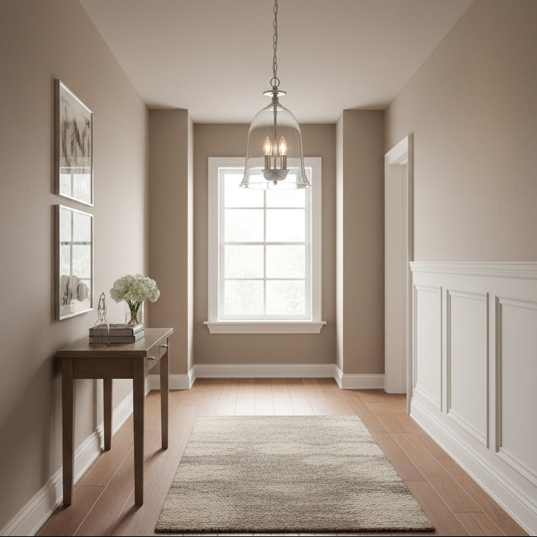 bell-shaped pendant features a clear glass shade paired with refined metal detailing, creating a light that feels both timeless and softly contemporary