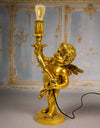 Gold cherub table light, perfectly formed cherubim hand outstretched holding a lamp.&nbsp; The lamp looks best with the addition of a filament bulb to add a glow.&nbsp; The lamp has a rococo decorative style working well in a luxurious bedroom, baroque styled living room - anywhere you need a touch of glamour.&nbsp; &nbsp;So decorative but also perfectly functional.&nbsp;