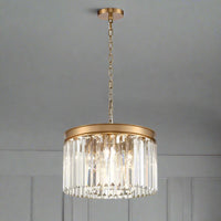 Gold metal rimmed crystal prism chandelier.&nbsp; Very high quality crystal prism drops suspended from a brushed gold finish metal surround.&nbsp; A statement in any room, perfect for a hall or bedroom to add a high end luxurious feel.