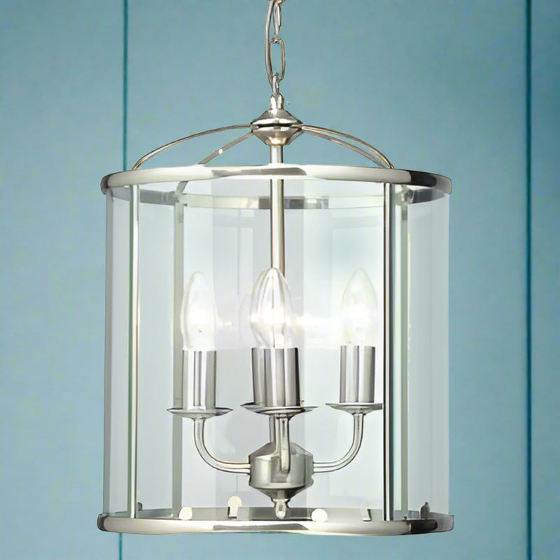 This elegant pendant light features a classic lantern design in antique chrome with four interior candle-style lights. The clear glass panels and polished metal frame create a timeless aesthetic that works beautifully in entryways, hallways, kitchens, and dining areas.