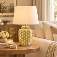 Lemon and white coloured, urn shaped ceramic lamp with a bright white fabric shade. 