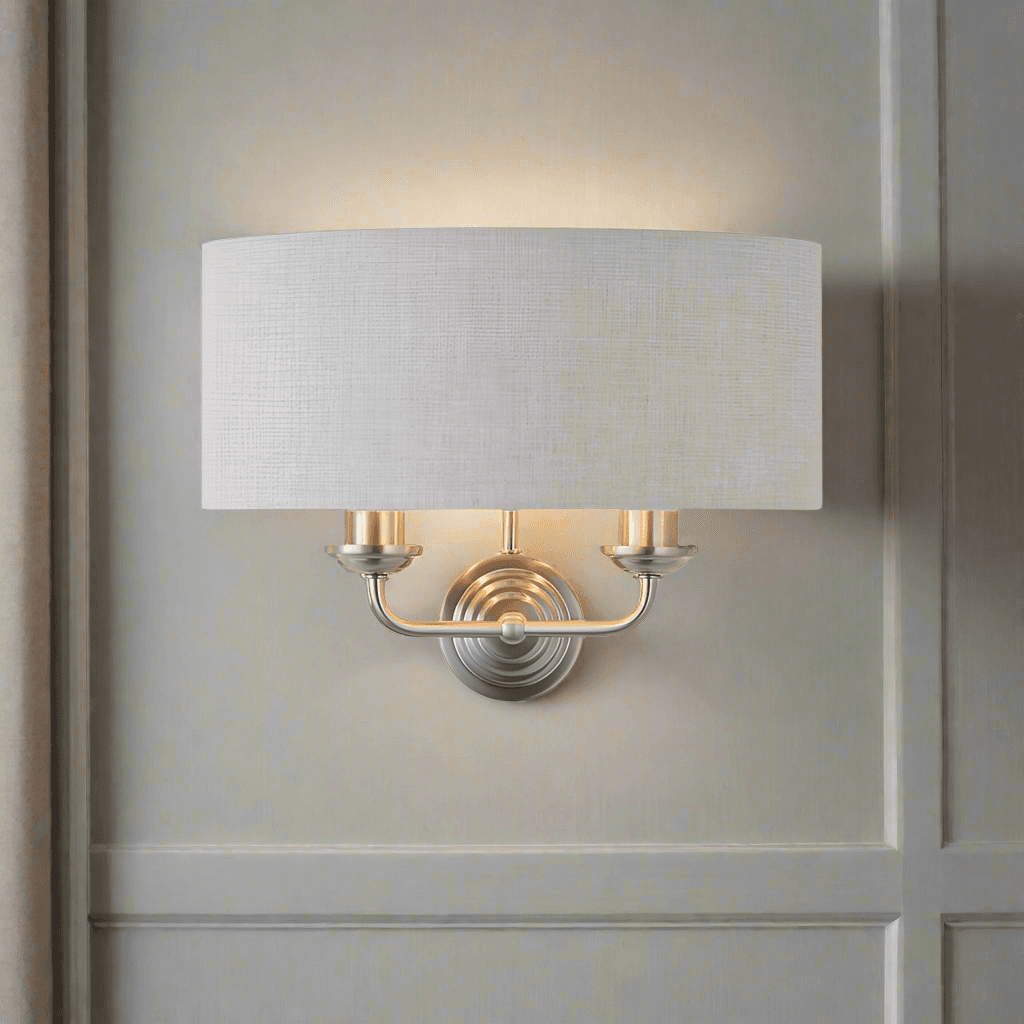 A natural linen half moon shade wall light with twin brushed chrome arms. This light emits a soft warm light perfect for a living, hallway, or bedroom space.