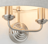 A natural linen half moon shade wall light with twin brushed chrome arms. This light emits a soft warm light perfect for a living, hallway, or bedroom space.