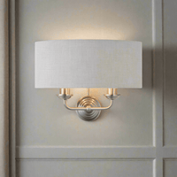A natural linen half moon shade wall light with twin brushed chrome arms. This light emits a soft warm light perfect for a living, hallway, or bedroom space.