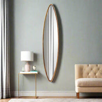 A very tall and narrow oval gilt framed mirror in a living room