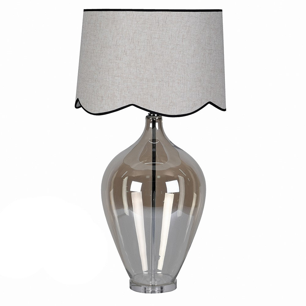This table lamp has an unusual luminescent, ombre style glass base in an urn shape.&nbsp; It is polished and clear to give a clean, modern look whilst still allowing light to reflect&nbsp; through it. The empire style shade with a scalloped lower edge adds a soft decorative detail tat contrasts with the clean lines of the glass base.&nbsp; The overall effect is of a traditional elegance with a modern twist. A really tall statement lamp and shade.