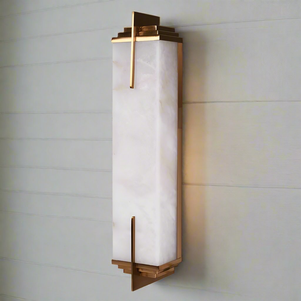 Art Deco style m wall light.&nbsp; A typical art deco, odeon style wall light with stepped antique brass decoration to the top and base. The marble encased in a geometric styled antique brass metal. Streamlined finish to add a subtle glow to any wall.&nbsp;&nbsp; In a living room or bedroom these lights will give an opulent feel.