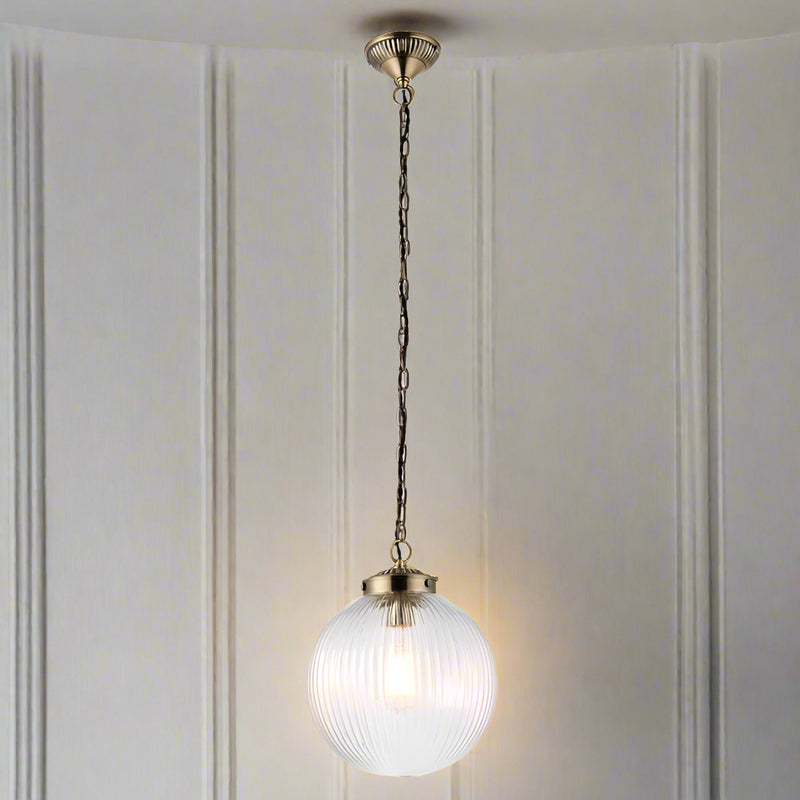 Ribbed glass globe pendant with antique brass fittings. Unusual ribbed circular globe light, disperses light softly in your space, ideal hall light or in a kitchen, over an island, a versatile light to suit any decor.