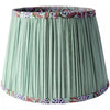 Mint Green Tapered Cotton Lamp Shade
Bring warmth and elegance to your home with this pleated green lampshade. Crafted with fine fabric and subtle detailing, the soft pleats create a classic silhouette that diffuses light beautifully, casting a golden glow in any space. The trim is delicately patterned, adding a touch of character while keeping the design versatile and timeless. Featuring a beautiful hand block printed pattern on the inside,