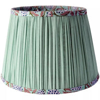 Mint Green Tapered Cotton Lamp Shade
Bring warmth and elegance to your home with this pleated green lampshade. Crafted with fine fabric and subtle detailing, the soft pleats create a classic silhouette that diffuses light beautifully, casting a golden glow in any space. The trim is delicately patterned, adding a touch of character while keeping the design versatile and timeless. Featuring a beautiful hand block printed pattern on the inside,