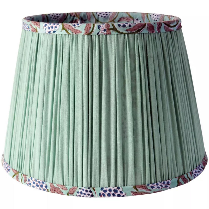 Mint Green Tapered Cotton Lamp Shade
Bring warmth and elegance to your home with this pleated green lampshade. Crafted with fine fabric and subtle detailing, the soft pleats create a classic silhouette that diffuses light beautifully, casting a golden glow in any space. The trim is delicately patterned, adding a touch of character while keeping the design versatile and timeless. Featuring a beautiful hand block printed pattern on the inside,