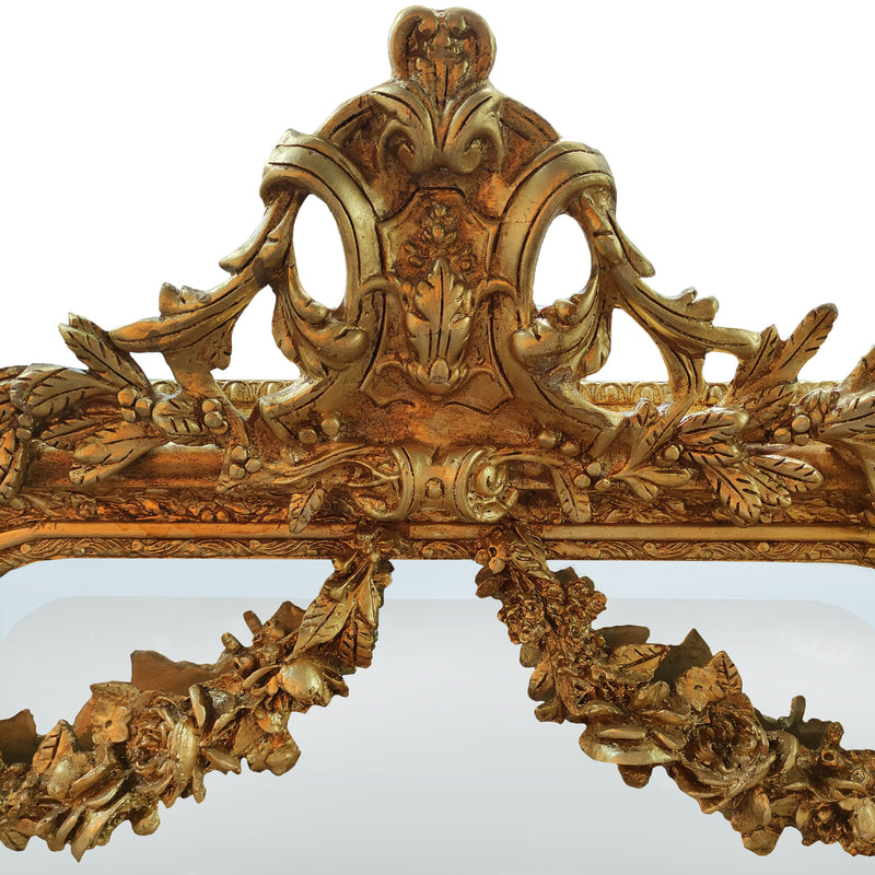An elaborate, ornate wall mirror, framed with swags, garlands, acanthus leaves and other embellishments in the Georgian neoclassical style, exceptional quality with a beautifully carved wooden frame. 
