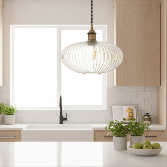 Ribbed glass and brass metal pendant light in an oval, pumpkin shape. Great over a kitchen island or anywhere in the kitchen.