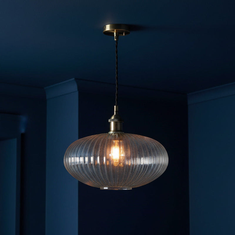 Ribbed glass and brass metal pendant light in an oval, pumpkin shape. Great over a kitchen island or anywhere in the kitchen.