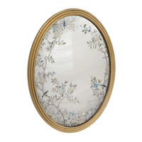 A decorative gilt framed oval wall mirror painted in the 'Victorian' style with floral motifs. A light-enhancing reflective glass surface. 