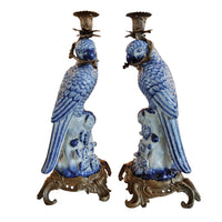 Pair of blue and white ceramic parrot candle holders on a white background