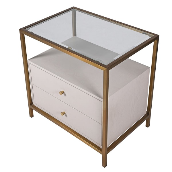 A stunning bedside table consisting of two pale wooden drawers set in a glass and gilt frame. Luxurious bedsides can make a bedroom and this example with sleek metal frame in a brushed brass finish is one of the best.&nbsp; The frame is topped with glass and there is space between the glass and the drawer to be used as a useful open shelf. A great contemporary look, exceptional quality, perfect luxury bedroom furniture.