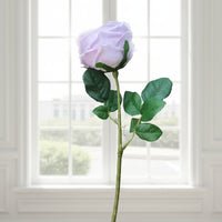 This ultra-realistic artificial lilac rose features rich, velvet-like petals and a vibrant green stem with textured leaves