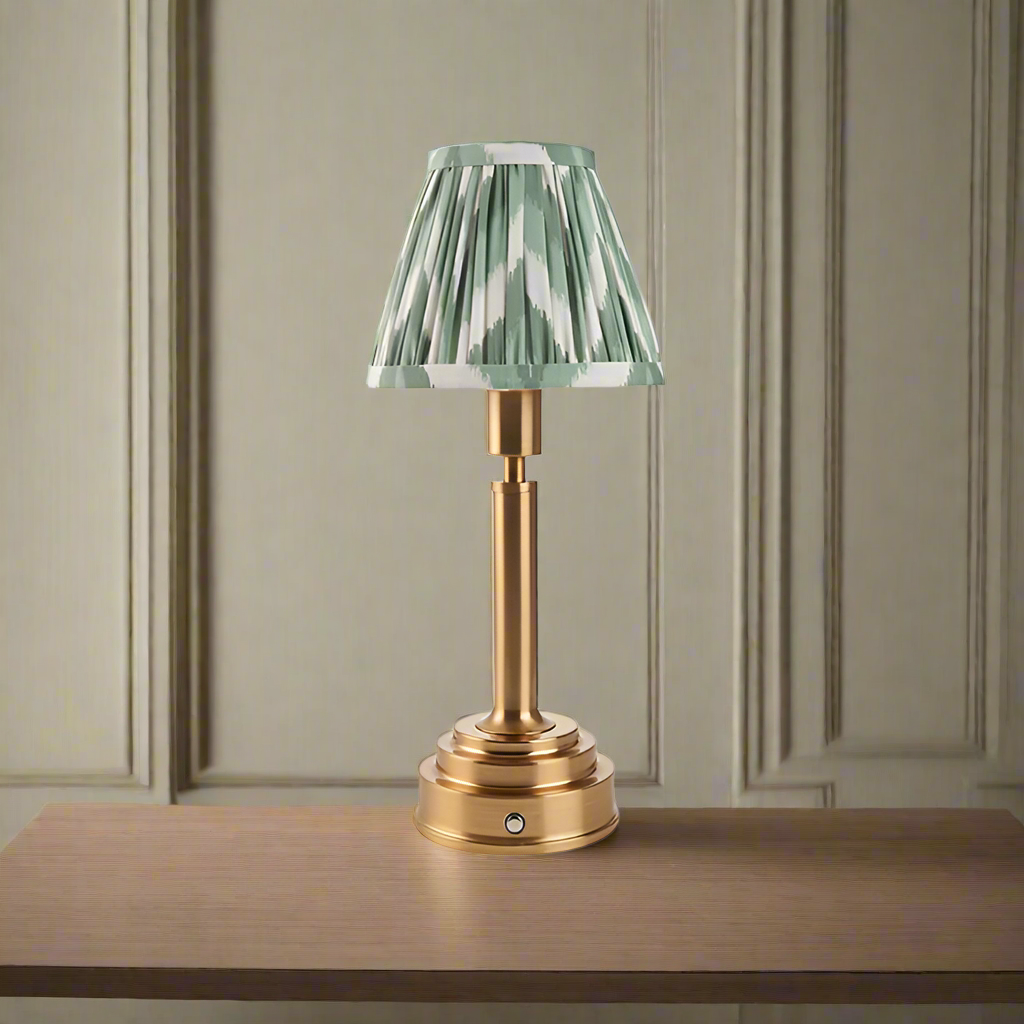 Brushed gold, rechargeable table lamp with a USB port.&nbsp; This portable, rechargeable 3 stage touch dimmer table lamp allows you to set your desired level of light.
They include a USB cable and an integrated warm white LED bulb.
These lamps are so convenient, can be placed wherever needed, no wires or plugs. Perfect for dining tables, desks or bedrooms. Can even be used outdoors making this a totally versatile lighting solution for your home.
Combine them with a beautiful pleated clip shade in three diff