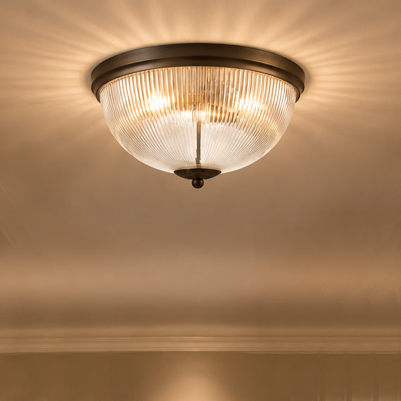 Flush mount ceiling light fixture with a ribbed clear glass shade in a hallway
