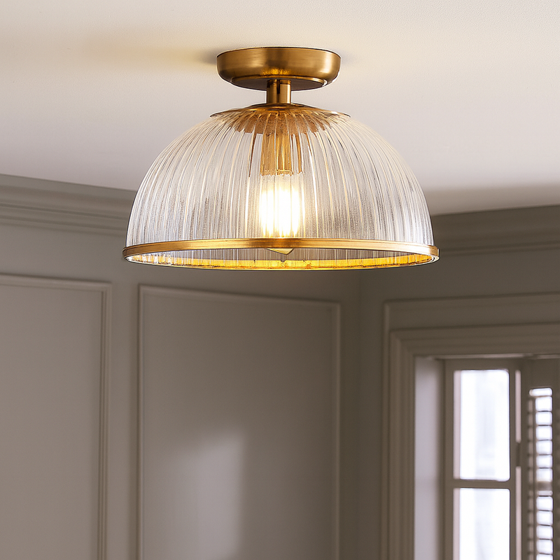 Ribbed glass flush ceiling light with gilt metal detailing. Designed to combine classic sophistication with modern functionality, this semi-flush mount light fixture features a dome-shaped ribbed glass shade that diffuses light beautifully.