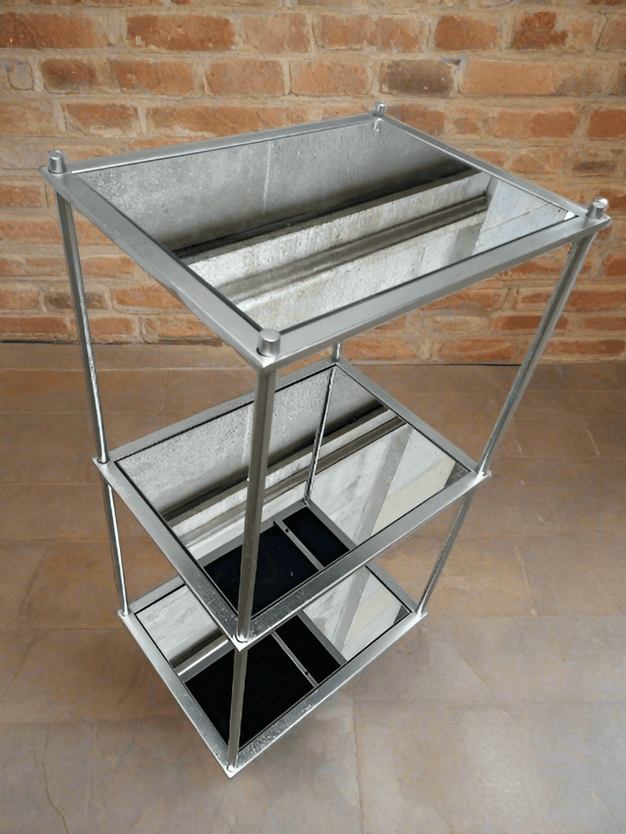 This silver leafed metal and mirrored glass three tiered shelf unit is perfect for upstyling any room while adding extra storage. A perfect piece to declutter and organise and your space. An highly versatile, attractive piece of furniture to elevate your space.